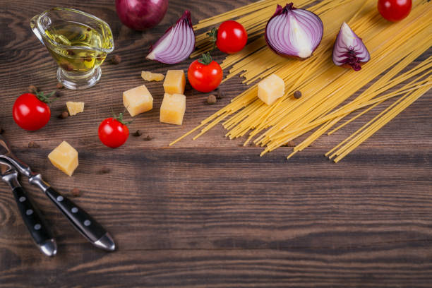 istock Ingredients for cooking spaghetti - raw pasta, tomato, olive oil, spices, herbs 968416394