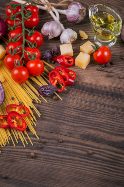 istock Ingredients for cooking spaghetti - raw pasta, tomato, olive oil, spices, herbs 968416418