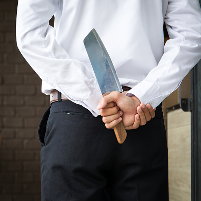 Man hidden knife behind in the concept photography of business.