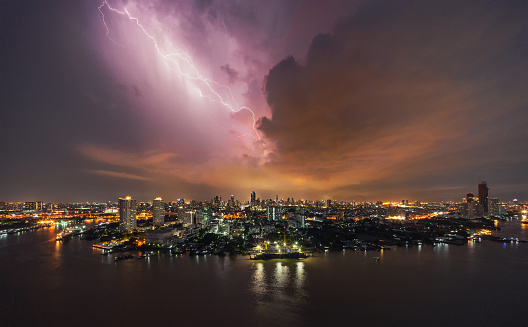 Thunder storm lightning strike over building area in Bangkok City at night, Thailand.