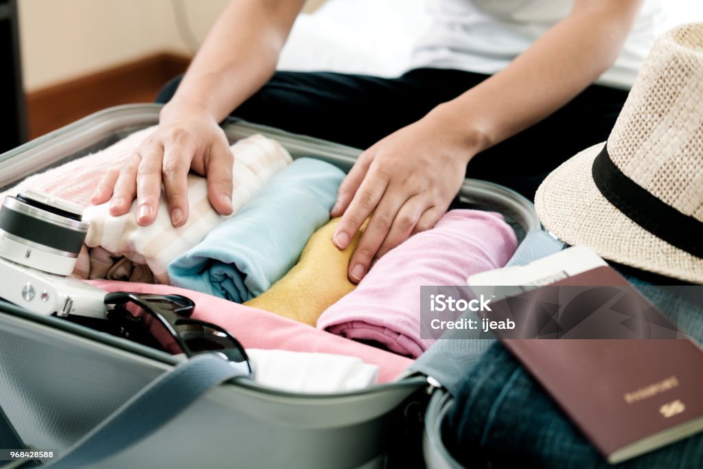 Preparation for vacation or travel. Preparation for vacation or travel. Packing his clothes and stuff into large opened suitcase that almost already full. Luggage Stock Photo