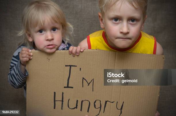 A Hungry Boy And A Girl With A Cardboard Tablet With The Inscription Im Hungry Stock Photo - Download Image Now