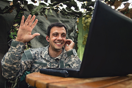 Army soldier video chatting with his family in the forest