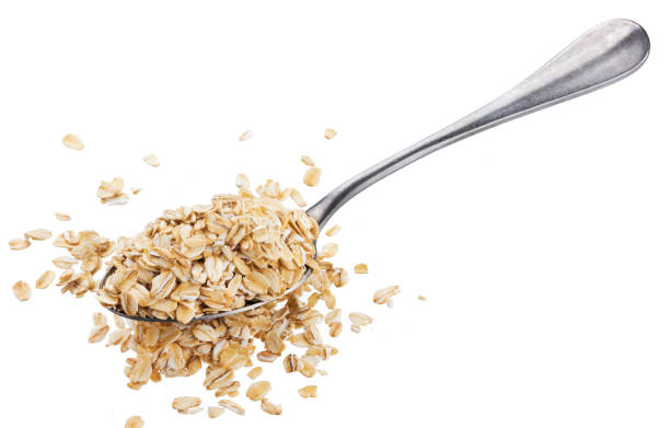 istock Oat flakes in spoon isolated on white background 968432454