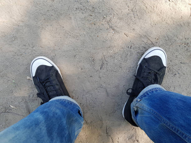 istock a man in black sneakers is standing on the sand. 968439572