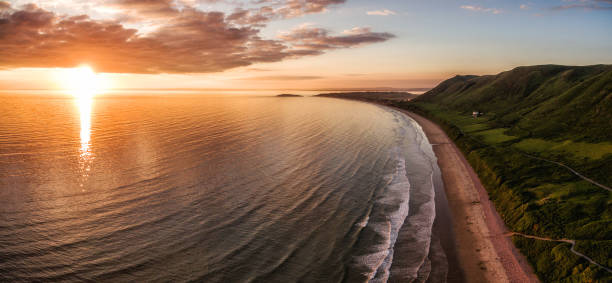 luftaufnahme des sonnenuntergangs im rhossili bay - tide aerial view wave uk stock-fotos und bilder