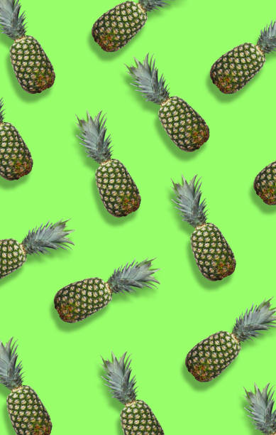istock Fresh pineapples on the green colorfurful background 968443336