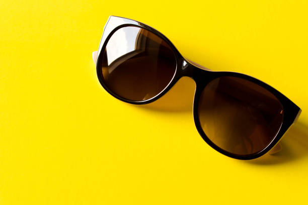 istock Sunglasses on yellow background. The concept of summer. Empty text space 968446406