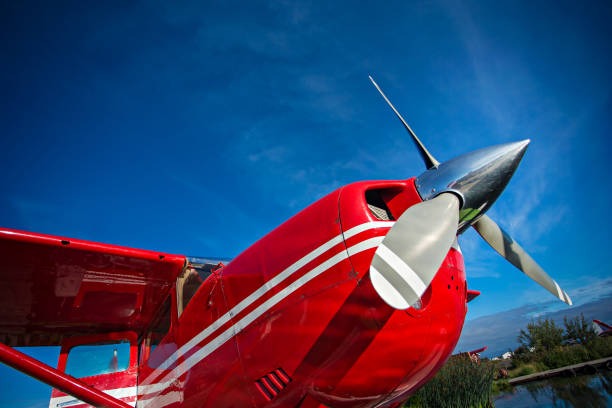 red seaplane at anchorage , alaska lake side with blue sunny sky