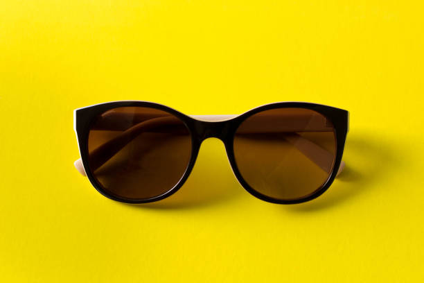 istock Sunglasses on yellow background. The concept of summer. Empty text space 968457576