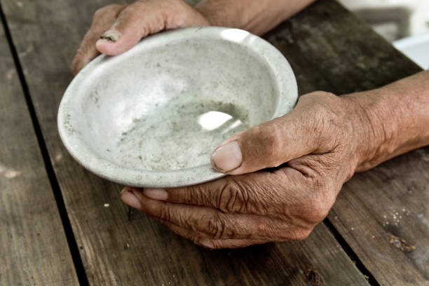 The poor old man's hands hold an empty bowl. The concept of hunger or poverty. Selective focus. Poverty in retirement.Homeless.  Alms The poor old man's hands hold an empty bowl. The concept of hunger or poverty. Selective focus. Poverty in retirement. Alms beg alms stock pictures, royalty-free photos & images