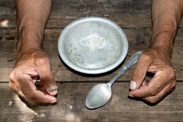 hands the poor old man's and empty bowl on wood background. The concept of hunger or poverty. Selective focus. Poverty in retirement.Homeless.  Alms hands the poor old man's and empty bowl on wood background. The concept of hunger or poverty. Selective focus. Poverty in retirement.Homeless.  Alms beg alms stock pictures, royalty-free photos & images