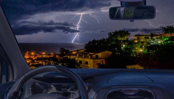 Looking through a car windshield with view of lightning storm over the sea