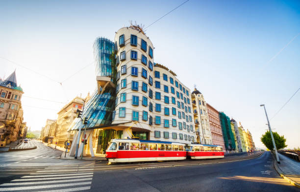 red tram in front of Dancing House (Tančící dům) in the morning. Prague 26 may 2018: Red tram passing in front of Dancing House building in Prague. Czech Republic prague art stock pictures, royalty-free photos & images