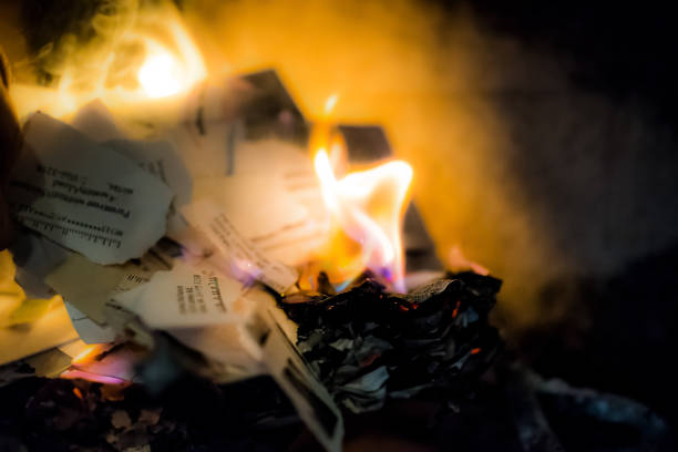 istock Burning paper, letters, documents with address, name, personal information in indoor home interior fireplace with closeup of orange, blue flame 968523440