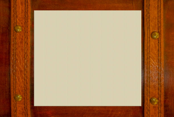 istock Wooden surface with leather straps an brass nails with paper space for copy in middle 968523682