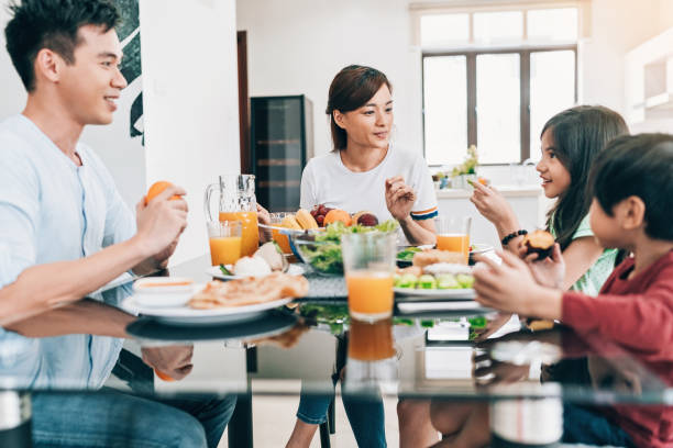 istock Mother, father and two children eating together 968533004
