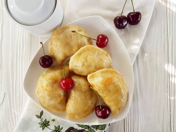 istock dumplings with a cherry on a white wooden background 968533238