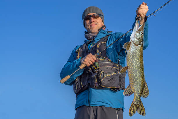 istock Happy fisherman with big pike fish trophy 968533406