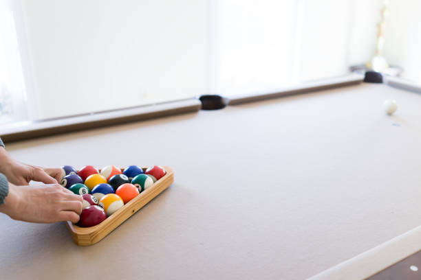 istock Interior house home with billiard pool table in living room, man moving triangle rack, setting up game 968533520