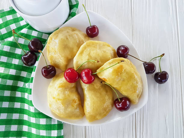 istock dumplings with a cherry on a white wooden background 968536770