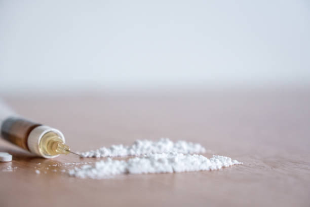 Heroin syringe needle with heroin and cocaine powder Heroin syringe needle with heoin or cocaine powder on the table. fentanyl addiction stock pictures, royalty-free photos & images