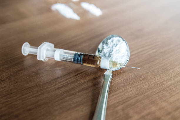 Heroin needle and a spoon of heroin. stock photo