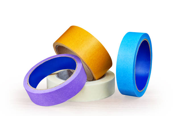 istock Blue, purple and yellow rollers of adhesive tape on white. 968540088