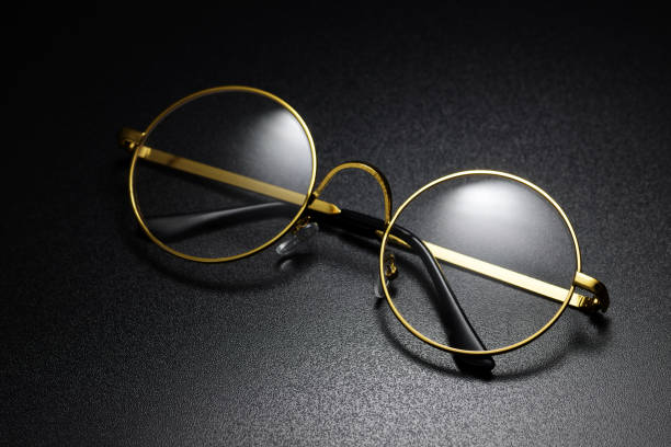 Gold frame classic round eyeglasses on the black background