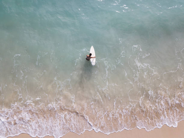 istock Surfer putting his surfboard into the ocean 968551828