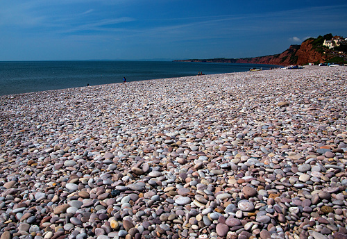 Very long shingle or pebble beach at Sidmouth Beech, Devon, England. Surrounded by large cliffs around the Bay.
