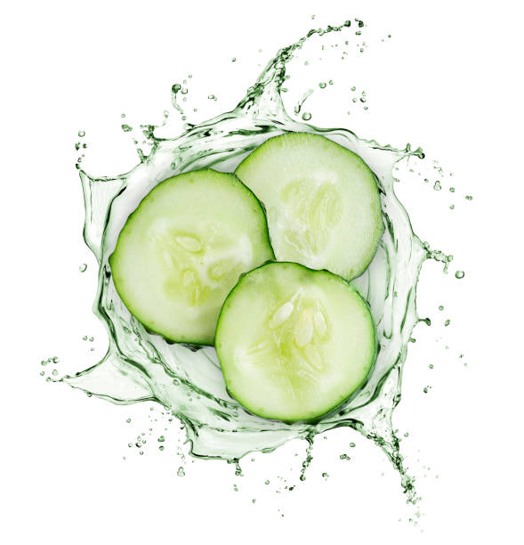 le fette di cetriolo ruotano in spruzzi di succo su sfondo bianco - cucumber foto e immagini stock