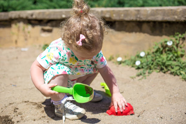 istock little girl is playing in the sand 968594388