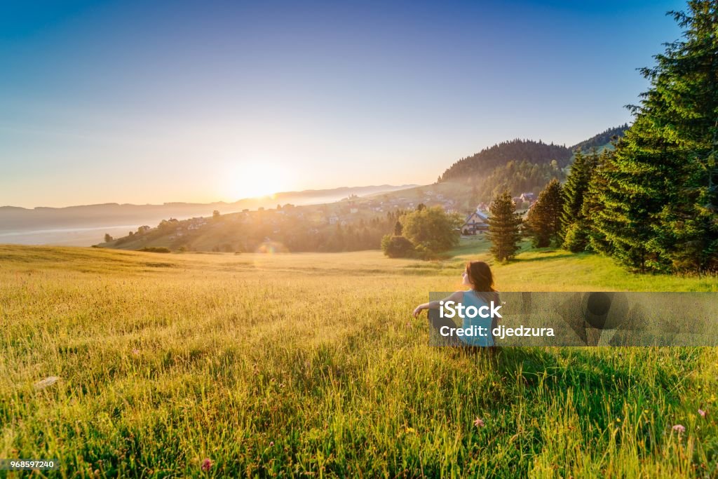 Female enjoying life at sunny morning. Female enjoying life at sunny morning. Happy young woman at mountains. Relaxation concept Mental Wellbeing Stock Photo