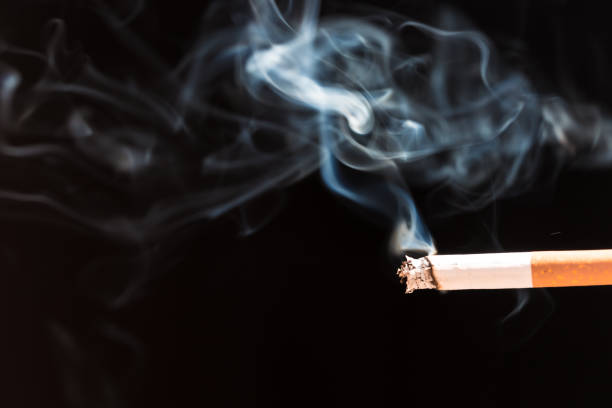 istock Burning cigarette with smoke and concept of cigarettes 968597328