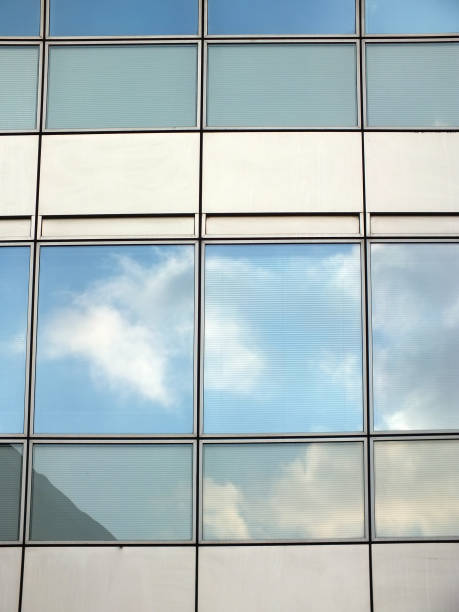 istock close up of modern office business building windows with reflected clouds 968605360