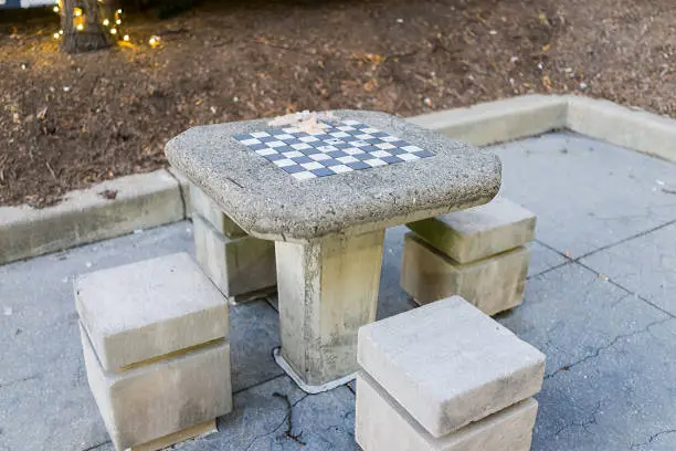 Empty chess table for homeless in park in Washington DC city capital with nobody in evening winter holiday lights, cold day