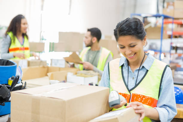 istock Mid adult woman scans boxes in distribution warehouse 968606032