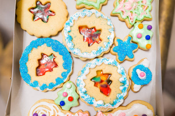 istock Tray gift paper box filled with many decorated icing glazed with candy sugar colorful artificial blue sprinkles Christmas holiday baked homemade cookies, snowmen, trees 968606246