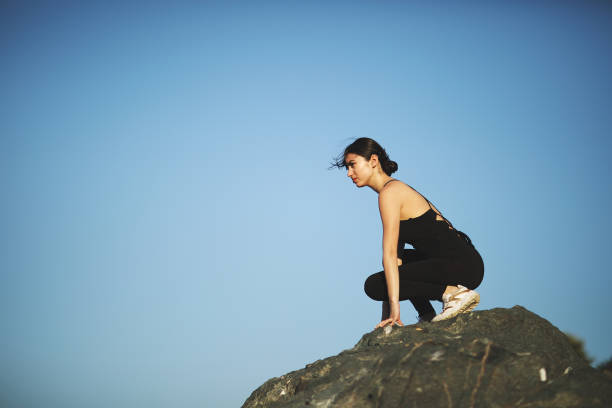 istock Young woman sitting on stone 968609056