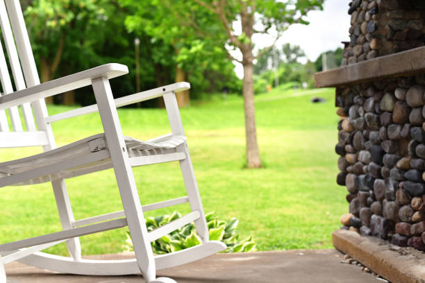 istock Serene patio scene with classic white rocking chair 968621288