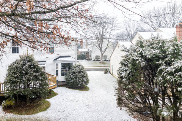 istock Backyards in neighborhood with snow covered ground, deck, trees, shrubs during blizzard white storm, snowflakes falling in Virginia suburbs, single family homes 968626092