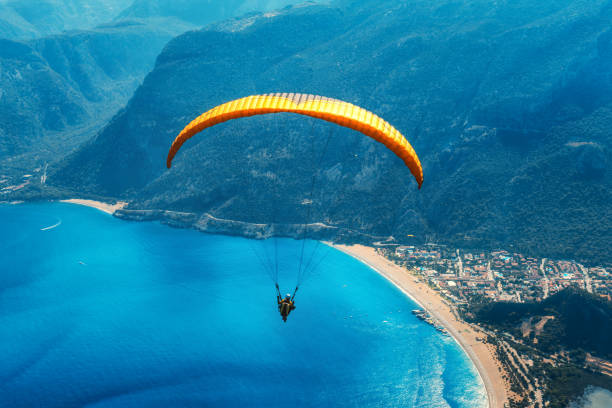 Paragliding in the sky. Paraglider tandem flying over the sea with blue water, beach and mountains in sunrise. Aerial view of paraglider and Blue Lagoon in Oludeniz, Turkey. Extreme sport. Landscape Paragliding in the sky. Paraglider tandem flying over the sea with blue water, beach and mountains in sunrise. Aerial view of paraglider and Blue Lagoon in Oludeniz, Turkey. Extreme sport. Landscape jump jet stock pictures, royalty-free photos & images