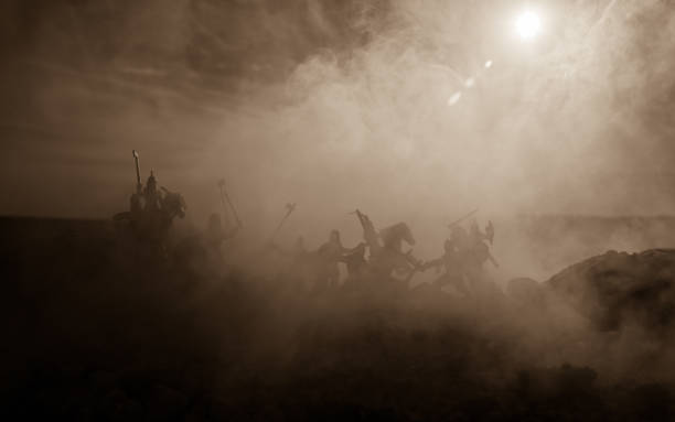 istock Medieval battle scene with cavalry and infantry. Silhouettes of figures as separate objects, fight between warriors on sunset foggy background. 968631312