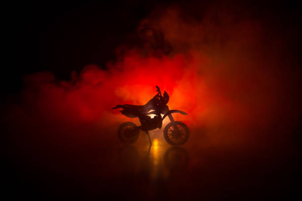 istock High power motorcycle chopper. Fog with backlights on background with man rider at night. Empty space 968631354