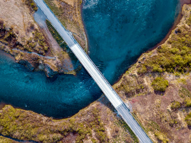 istock Countryside road over blue river from above. 968633588