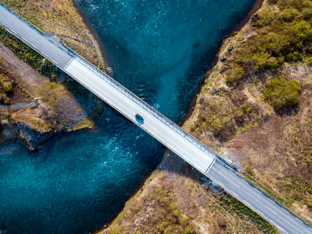istock Car driving over bridge  in Iceland with fresh water running under. 968633596