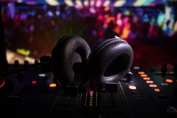 istock In selective focus of Pro dj controller.The DJ console deejay mixing desk at music party in nightclub with colored disco lights. 968636312