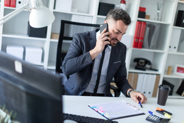 istock A man is sitting in the office at the table, talking on the phone and working with documents. 968637160