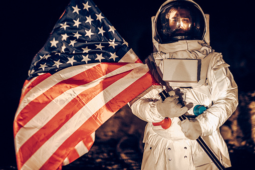 American spaceman placing American flag to mark the territory